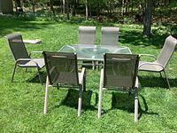 Full view of table, six chairs, umbrella removed, covers on grass