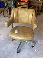 Front view of vintage office chair with vinyl upholstery and chrome aluminum base on casters. Shows seat, backrest, armrests, and caster wheels.