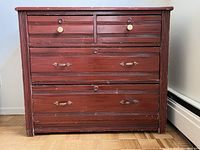 Frontal view of vintage solid wood dresser showing six drawers with different hardware. Paint is worn and chipped in areas. Drawers do not move smoothly.