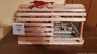 Front and side view of wooden lobster cage with blue netting and red lobster figurine on top