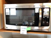 Front view of GE microwave oven showing stainless steel and black control panel.
