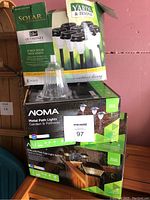 Three sets of outdoor lights stacked together including Outshines solar path lights, Noma metal path lights, and solar deck post cap light set.