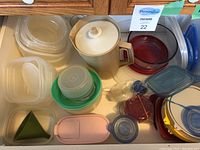 Photo of assorted plastic storage containers with lids, beige pitcher also visible.