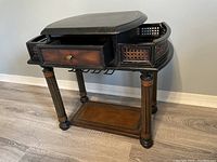 Photo of wooden bar/side table showing drawer, cane panel sides, legs, and bottom shelf.