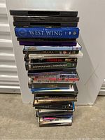 Stack of 26 DVDs with visible titles including The West Wing, Osama, Command & Conquer.