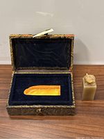 Photo showing the carved jade seal in a lined box and the jade figurine placed beside it