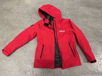 Red Nintendo Switch branded Stormtech jacket laid flat showing front with hood and zippered pockets.
