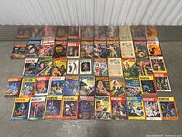 Wide view showing all 49 vintage Startling Stories and Universe sci-fi magazines laid out on the ground, colorful illustrated covers from 1950s era visible.