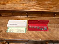 1987 uncirculated coin set with outer box and certificate on wooden surface