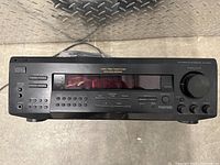 Front view of the black Technics Audio/Video Control Center with multiple control buttons, display screen and headphone jack.