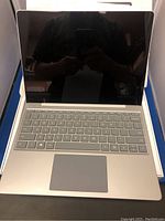 Open box view of the Surface Laptop Go showing screen turned off, full-size keyboard and trackpad