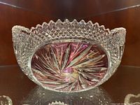 Close-up of large crystal punch bowl showing scalloped rim, diamond texture, and star cut pattern on bottom