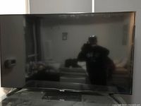 Photo of Samsung flat screen TV powered off reflecting surroundings.