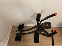 Full view of Ab-flex home fitness equipment showing structure, handles, digital counter, and foam rollers.