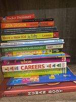 Photo of a stacked set of educational and story books, mostly paperbacks and some hardcovers, suitable for middle school.