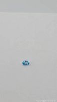 Photo showing the oval cut Swiss blue topaz gemstone with clear lagoon blue color on white background.