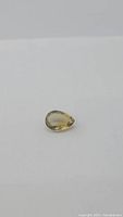 Natural pear cut golden citrine gemstone shown on a plain white background.
