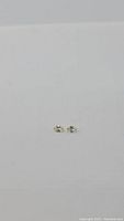 Pair of small oval cut zircon gemstones photographed on a white background showing light champagne color.