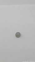Oval smoky silver colored moonstone cabochon photographed on white background from a close distance showing size and coloring