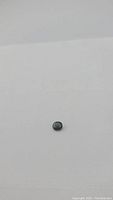 Oval cut natural green sapphire gemstone shown on white background for visual details and color.