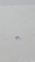 Oval cut natural sky blue topaz gemstone on plain background showing clarity and color.
