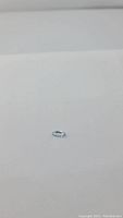 Photo of the light blue marquis cut aquamarine gemstone on white background.