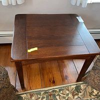 Top view of wooden side table showing grain, panel design, and scratches.