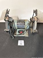 Front view of the Delta 6 inch Trim-Line Bench Grinder showing grinding wheels, protective guards, and power cord.