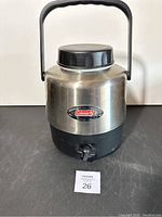 Full front view of the Coleman steel belted cooler jug showing handle, lid, and spigot.