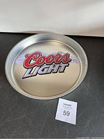 Full view of round silver metal tray with Coors Light logo and mountain graphic on surface.