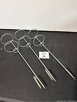 Set of three stainless steel fishing rod ground holders placed on a flat surface, showing full length and round rod supports on top.