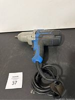 Side view of the MasterCraft electric impact wrench showing blue and black plastic body with silver metal front housing and attached power cord.