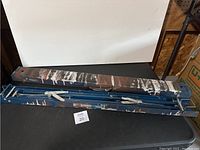 Folded MasterCraft blue metal sawhorse with visible paint splatters and wear marks, placed on black surface under lighting.