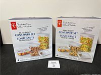 Two boxes of President's Choice Seal-Tight Container Sets, each box containing 4 containers shown with food inside on the packaging