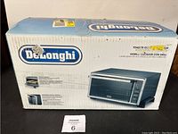 Photo of the boxed Delonghi toaster oven showing brand and packaging details.