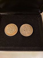 Obverse side of two Morgan silver dollars showing Liberty facing left wearing a Phrygian cap with the date 1921 and 1921S visible.