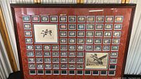 Front view of entire framed display showing stamps and two larger illustrations