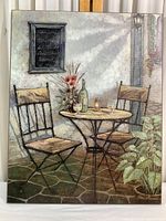 Full view of the mounted print showing the setting with chairs, table, wine bottle, glasses, flowers, and outdoor wall.