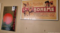 Photo showing both framed posters on a wall, Sayonara on the left and La Bohème on the right.