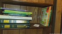 Shelves with gardening books and binders showing titles and condition.