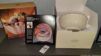 Photo showing Lenox bowl in box with foam padding, Rosenthal plate box with art plate image, and unbranded bowl box.