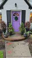 Front view of the six outdoor planters on the porch in front of purple door.