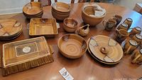 Full view of the Sango Splash ceramic dishes including multiple bowls, plates, a square baking dish, serving plate, and mugs arranged on a wooden table.