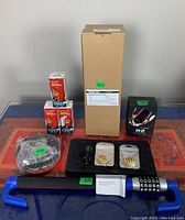 All items arranged on table including lock, vacuum box, wireless charger box, deodorizers, decals, keys, manuals