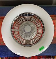Top view of round ceiling fan light with metallic guard and white outer rim
