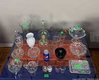Full view of the collection on a table with colorful tablecloth, showing all glass, crystal, and related items.