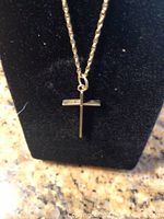 Twisted rope chain displayed on a black velvet stand with cross pendant