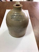 Front view of 1 gallon stoneware jug showing stamped text indicating merchant and location in Quebec.