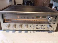 Front view showing silver faceplate, illuminated tuning dial, control knobs and indicator lights.