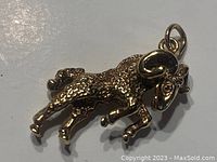Front view of 10K gold Aries ram pendant showing textured body and polished horns with bail.